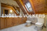This stunning bathroom boasts a unique wooden beamed ceiling and skylights, creating a bright and airy atmosphere.