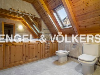 This stunning bathroom boasts a unique wooden beamed ceiling and skylights, creating a bright and airy atmosphere.