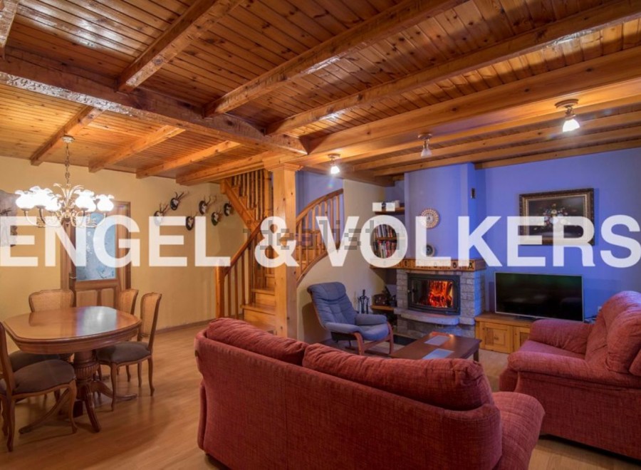 Rustic mountain home with wooden beams, a cozy fireplace, and ample living space.