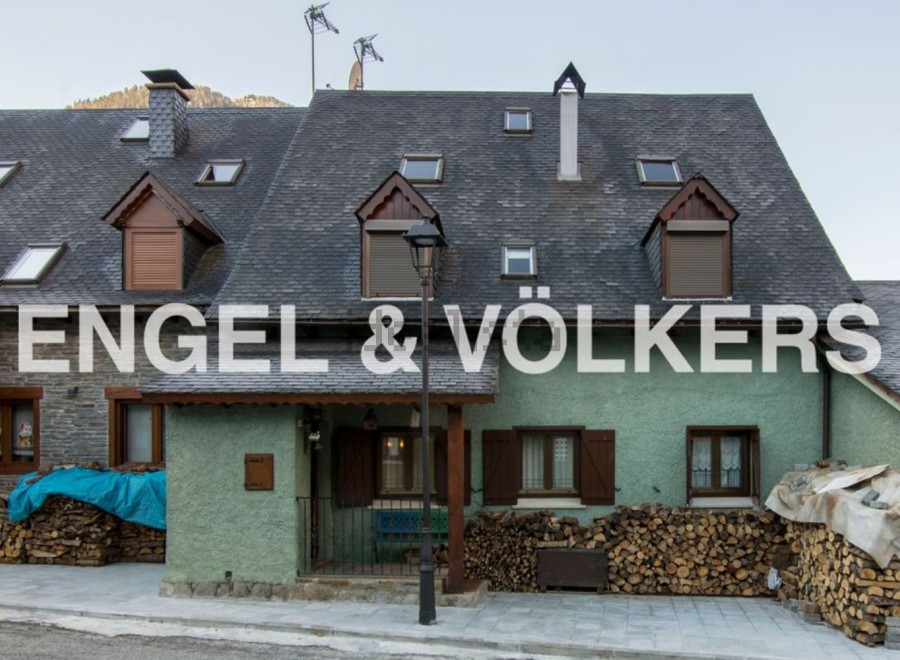 Charming mountain home with slate roof and wood storage.