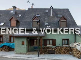 Charming mountain home with slate roof and wood storage.