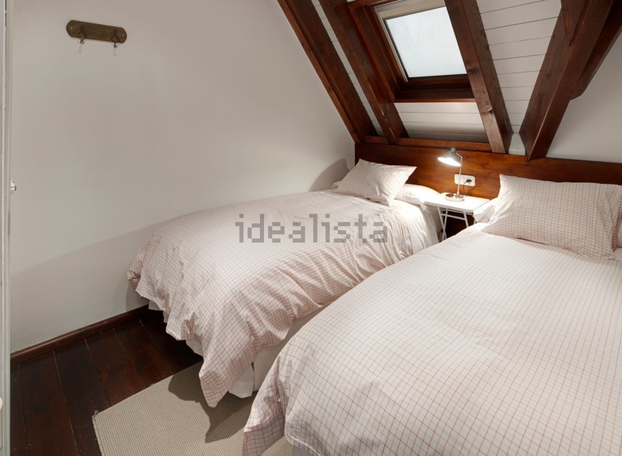 Charming attic bedroom with twin beds, perfect for a cozy getaway.