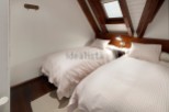 Charming attic bedroom with twin beds, perfect for a cozy getaway.
