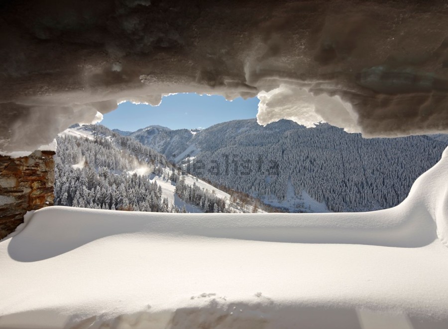 Escape to this stunning mountain chalet, where breathtaking views await from your snow-covered window seat.
