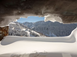 Escape to this stunning mountain chalet, where breathtaking views await from your snow-covered window seat.