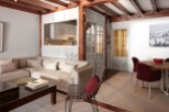 This charming apartment boasts a spacious living area with a comfortable sectional sofa and a stylish coffee table, perfect for relaxation.