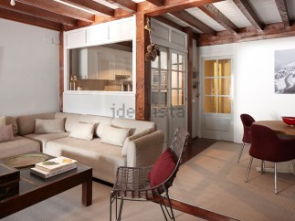 This charming apartment boasts a spacious living area with a comfortable sectional sofa and a stylish coffee table, perfect for relaxation.