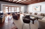 This stunning property boasts a spacious open-plan living area with hardwood floors and exposed wooden beams, creating a warm and inviting atmosphere.