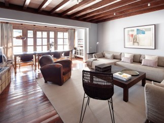 This stunning property boasts a spacious open-plan living area with hardwood floors and exposed wooden beams, creating a warm and inviting atmosphere.