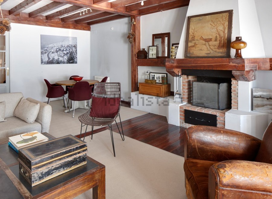 Rustic mountain chalet with exposed wooden beams, a cozy fireplace, and ample living space.