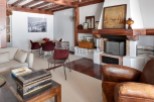 Rustic mountain chalet with exposed wooden beams, a cozy fireplace, and ample living space.