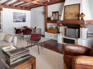 Rustic mountain chalet with exposed wooden beams, a cozy fireplace, and ample living space.