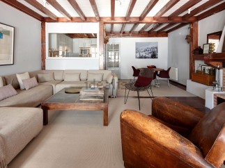 This stunning property boasts a spacious living area with exposed wooden beams, creating a warm and inviting atmosphere.