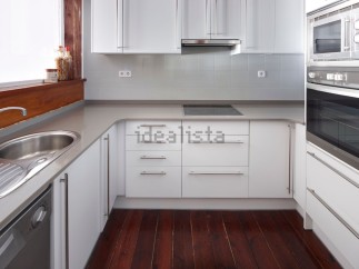 Modern kitchen with white cabinets and grey countertops.