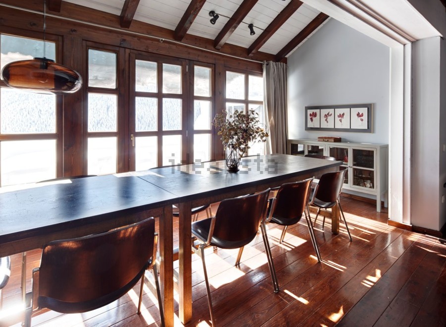 This stunning chalet boasts a spacious dining area with a large wooden table perfect for family gatherings.