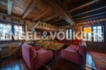Rustic mountain home with exposed wooden beams, a large stone fireplace, and comfortable seating.