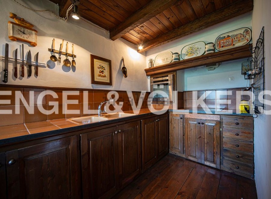 Rustic kitchen with wooden cabinets and countertops, featuring a charming vintage aesthetic.