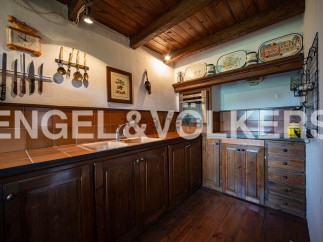 Rustic kitchen with wooden cabinets and countertops, featuring a charming vintage aesthetic.