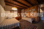 Charming rustic bedroom with twin beds, wooden beams, and vintage car artwork.