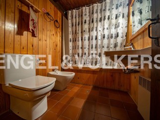 Rustic bathroom with wooden walls and tiled floor.