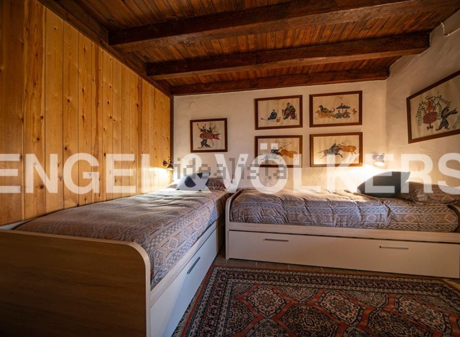 Charming rustic bedroom with twin beds, wooden walls, and unique artwork.