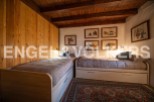 Charming rustic bedroom with twin beds, wooden walls, and unique artwork.
