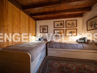 Charming rustic bedroom with twin beds, wooden walls, and unique artwork.