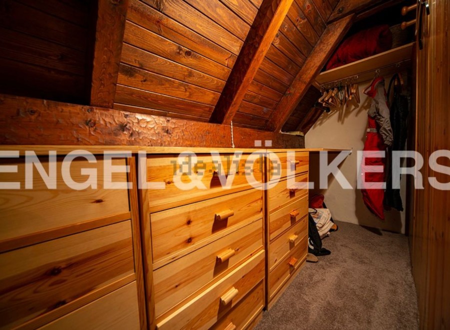 Charming attic room with built-in wooden drawers offering ample storage.