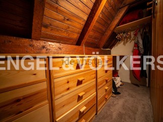 Charming attic room with built-in wooden drawers offering ample storage.