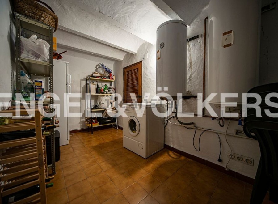 This charming property boasts a spacious laundry room, complete with ample storage shelving and a convenient wine rack.