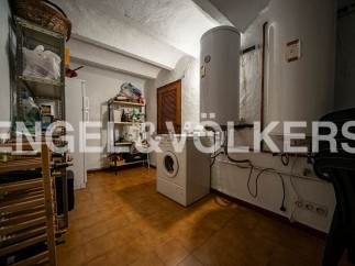 This charming property boasts a spacious laundry room, complete with ample storage shelving and a convenient wine rack.