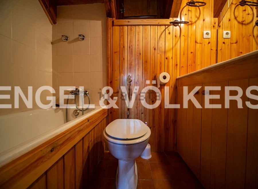Charming bathroom with wooden finishes and a bathtub.