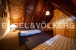 Cozy attic bedroom with wooden beams and built-in beds, perfect for a mountain getaway.