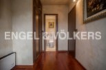 This stunning property boasts a spacious hallway with rich hardwood floors, leading to a well-appointed bathroom.