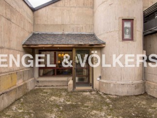 This unique property boasts a striking concrete exterior with a blend of modern and rustic design elements.