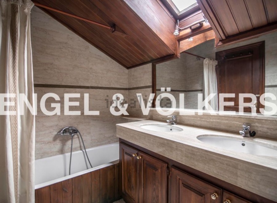 Charming attic bathroom with wooden finishes and a skylight.