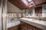 Charming attic bathroom with wooden finishes and a skylight.