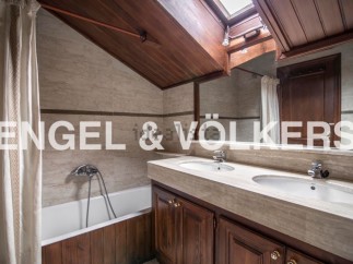 Charming attic bathroom with wooden finishes and a skylight.