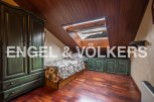 Charming attic room with wooden floors and a skylight offering mountain views.