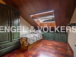 Charming attic room with wooden floors and a skylight offering mountain views.