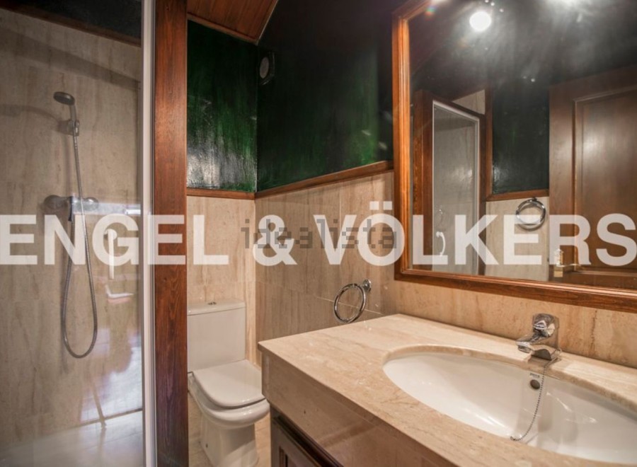 This stunning bathroom boasts a spacious shower, modern sink, and elegant toilet.