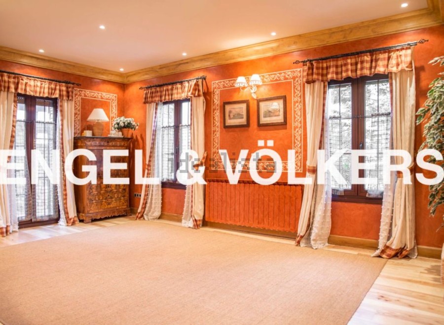 This stunning property boasts a spacious and bright living area with large windows, hardwood floors, and elegant drapery.