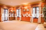 This stunning property boasts a spacious and bright living area with large windows, hardwood floors, and elegant drapery.
