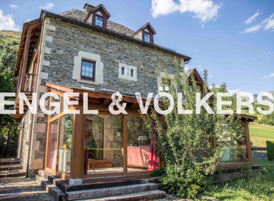 This stunning stone house boasts a spacious sunroom, perfect for enjoying the mountain views.