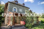 This stunning stone house boasts a spacious sunroom, perfect for enjoying the mountain views.
