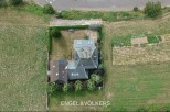 This charming property boasts a spacious house with a unique architectural design, surrounded by lush greenery and a well-maintained garden.