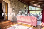 Sun-drenched solarium with stunning mountain views, featuring a cozy red sofa and hardwood floors.