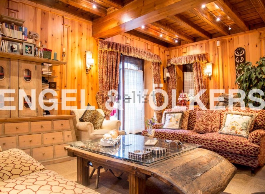 This stunning chalet boasts a warm and inviting living area, complete with wood paneling and exposed beams.
