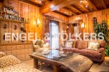 This stunning chalet boasts a warm and inviting living area, complete with wood paneling and exposed beams.