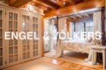 This luxurious bedroom boasts a stunning four-poster bed, custom-built wardrobes, and exquisite wooden beams.
